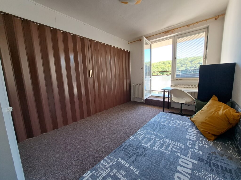 Accommodation for students in Brno on Myslivní. Half of the room with a balcony is created when you close the accordion door in the middle of the room.