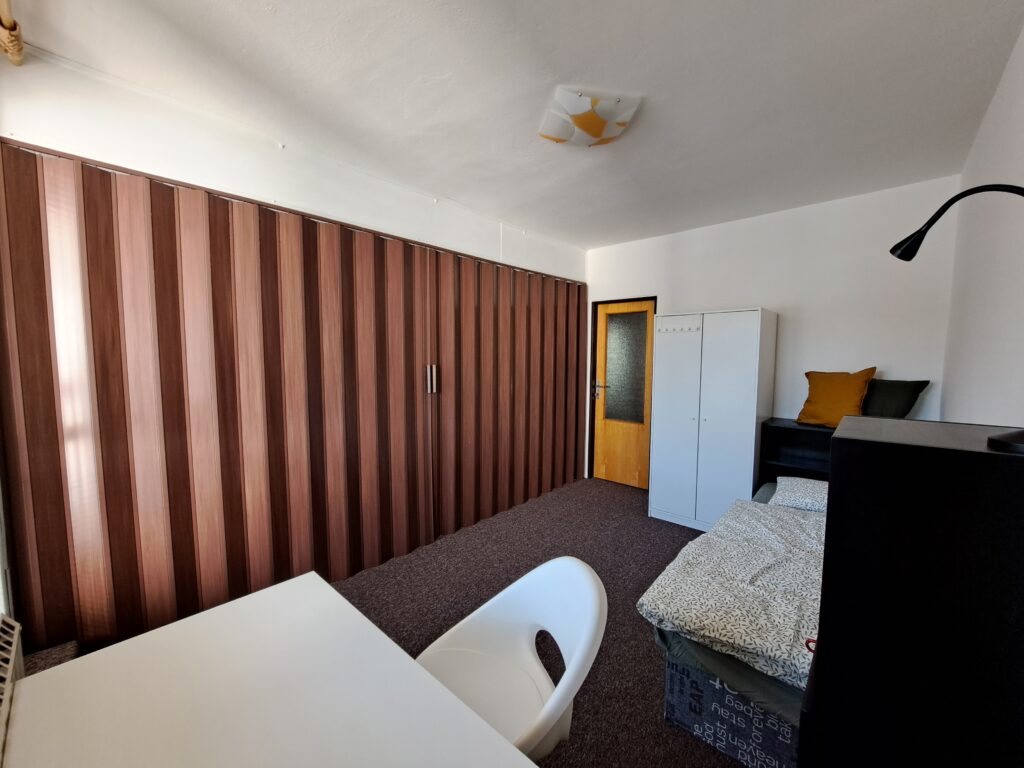 Accommodation for students in Brno on Myslivní. Room with balcony with accordion door in the middle of the room.